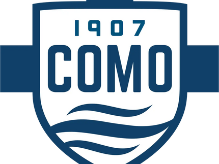 Logo a forma di scudo blu e bianco con 1907 sopra como e linee ondulate stilizzate sotto nella collezione COMO