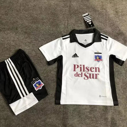 Maglia bimbo colo-colo home 2022 23 adidas bianca e nera con scritta rossa pilsen del sur tre strisce e stemma squadra