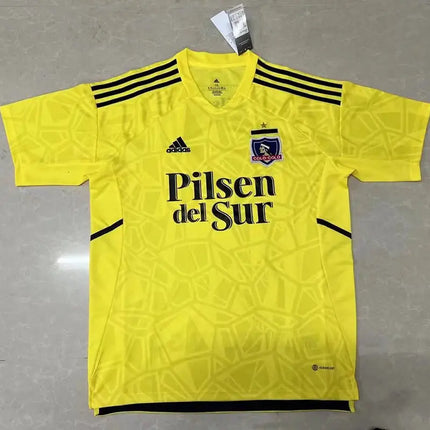 Maglia 1 portiere gialla colo-colo 2022 23 con strisce nere motivo geometrico e logo sponsor pilsen del sur