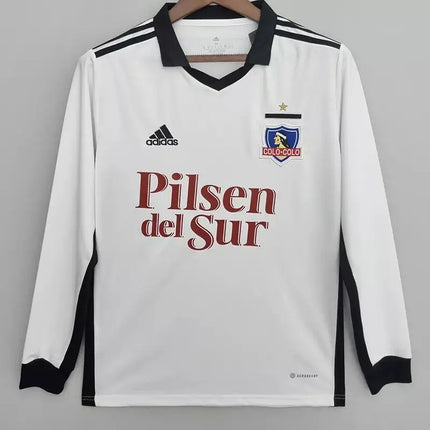 Maglia bianca maniche lunghe colo-colo home 2022/23 con colletto nero e logo pilsen del sur rosso sul petto