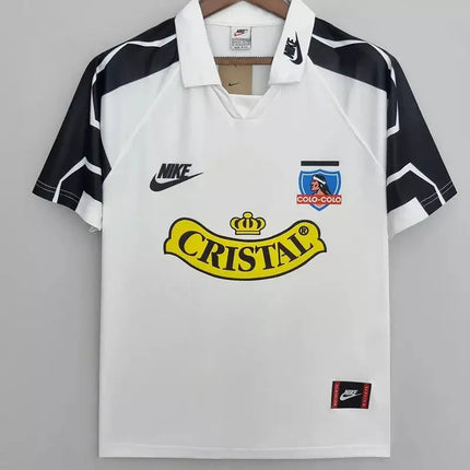 Maglia bianca retro colo-colo home 1995 96 con pannelli geometrici neri e bianchi sulle spalle e logo cristel giallo