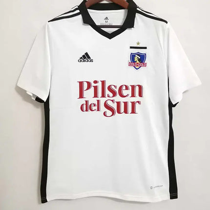 Maglia colo-colo home 2022/23 adidas bianca con rifiniture nere, logo sponsor pilsen del sur rosso e stemma del club