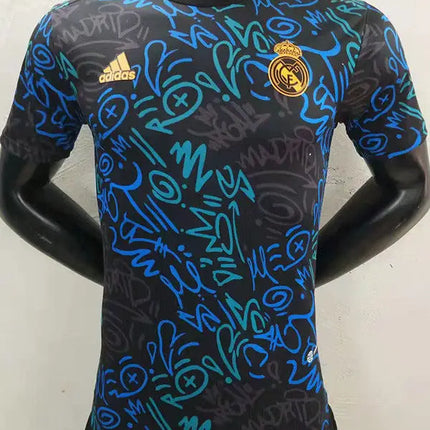 Maglia real madrid allenamento 2022/23 nera adidas con grafica graffiti blu e turchese vivaci per allenamento