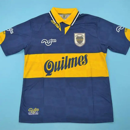 Maglia retro boca juniors home 1995 96 con strisce blu e gialle e logo quilmes prominente sul petto