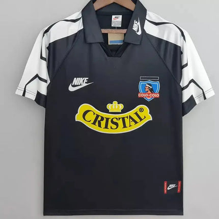 Maglia retro colo-colo trasferta 1995 96 nera con pannelli geometrici e logo cristall giallo sul petto