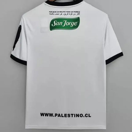 Terza maglia deportivo palestino 2022 23 vista posteriore con logo san jorge verde su jersey bianco con rifiniture nere